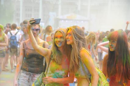 Фестиваль красок `Холи` в Лужниках. На снимке: девушки фотографируются на мобильный телефон.