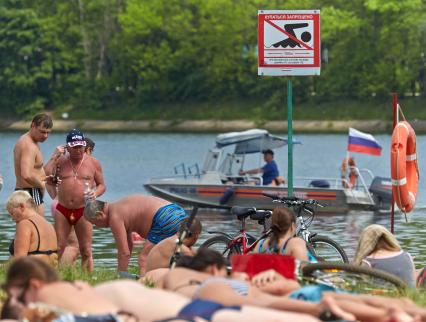 Отдыхающие люди на городском пляже.