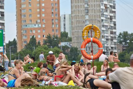 Загорающие люди на городском пляже.