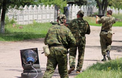 Славянск. Похороны старшей операционной сестры Татьяны Кубран, погибшей при минометном обстреле украинской армией по больнице. На снимке: ополченцы патрилируют кладбище.