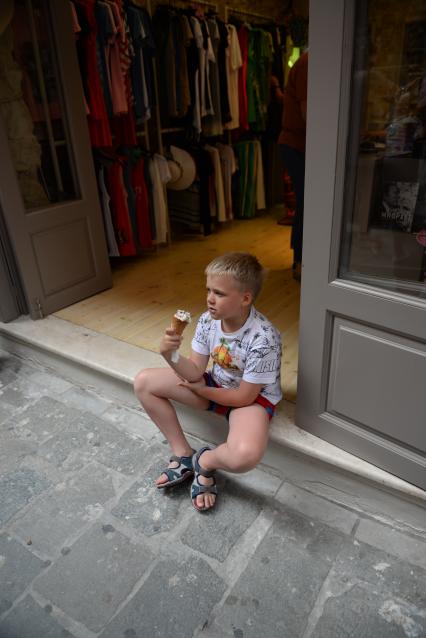 Крит. Поселок Бали. На снимке: мальчик с мороженым у магазина одежды.
