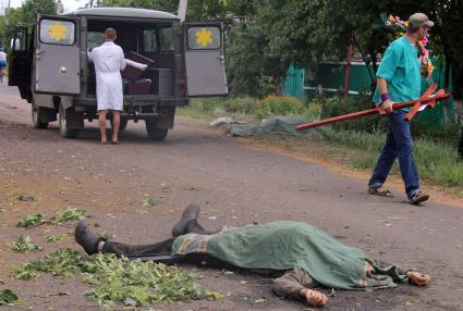 Поселок Восточный, подвергшийся ночью артобстрелу украинской армии. Погибли 3 пенсионера. На снимке: тела убитых Ольги и Владимира Черниковых. Владимир Черников - вдали справа от машины, его жена - накрытая одеялом.