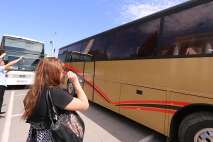 Луганск. На снимке: люди провожают близких, уезжающих на автобусе.