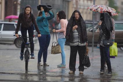 девушки и женщины стоят на перекрестке во время дождя