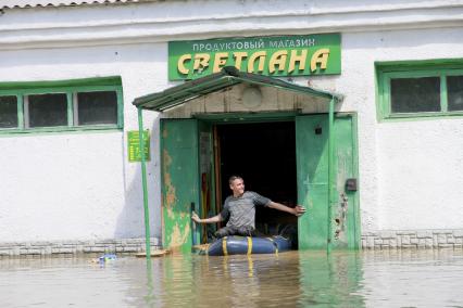 Наводнение в Алтайском крае. Поселок Затон. На снимке: мужчина на лодке выплывает из магазина.