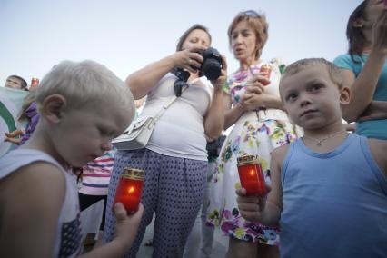 Двое мальчиков держат заженые лампадки во время проведения  акции \"Свеча памяти\" в Екатеринбурге