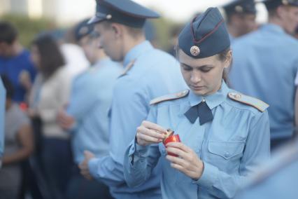 Девушка курсант МЧС закрывает зажженную лампаду перед проведением акции \"Свеча памяти\" в Екатеринбурге