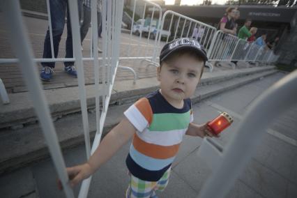 Маленький мальчик с зажженой лампадой открывает ограждение во время проведения акции \"Свеча памяти\" в Екатеринбурге