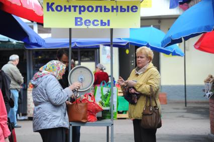 Преображенский торговый рынок. На снимке: женщина у контрольных весов.