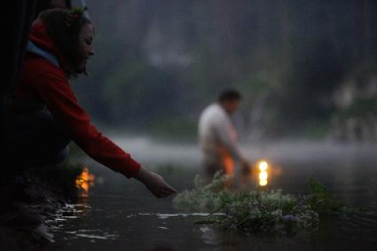 Девушкаво время  празднования дня Ивана Купала спускает на воду венок из цветов