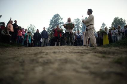Участникки празднования дня Ивана Купала стоят с венками в руках, перед их спуском на воду