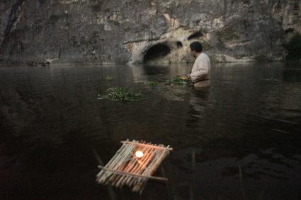 Участник празднования дня Ивана Купала стоят с венками в руках, по пояс в воде