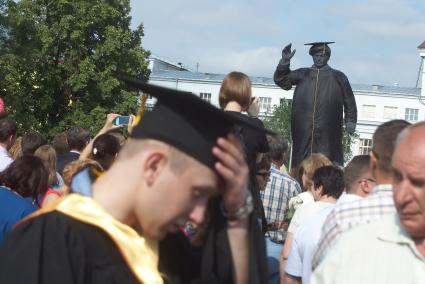 Выпускник УрФУ держится за голову,на заднем плане памятник Кирову одетый в чернуб мантию и конфедератку