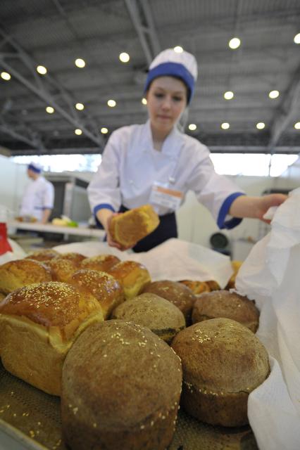 ВВЦ. Ежегодный форум для пекарей и кондитеров России `Праздник хлеба 2014`. На снимке: девушка раскладывает хлеб.