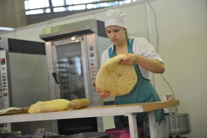 ВВЦ. Ежегодный форум для пекарей и кондитеров России `Праздник хлеба 2014`. На снимке: девушка заготавливает тесто.
