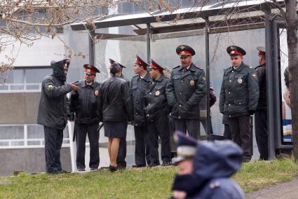 Полицейские стоят у остановки укрываясь от дождя после первомайского шествия в Екатеринбурге