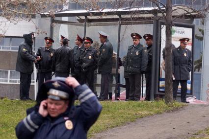 Полицейские стоят у остановки укрываясь от дождя после первомайского шествия в Екатеринбурге