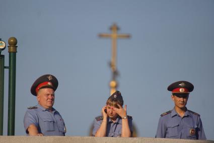 Полицейские стоят на фоне креста