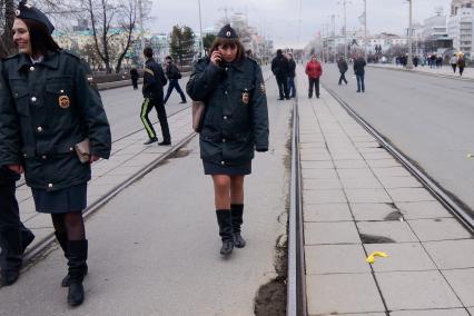 девушка-полицейский замерзла и разговаривает по телефону после первомайского шествия в еКАТЕРИНБУРГЕ