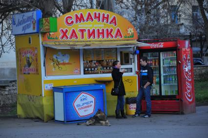 Севастополь. На снимке: люди стоят у палатки фаст-фуда `Смачна хатинка` (Вкусный домик).