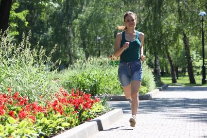 Девушка бежит по парку.