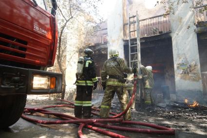 Пожарные ставят раздвижную лестницус балкону для тушения пожара на втором этаже