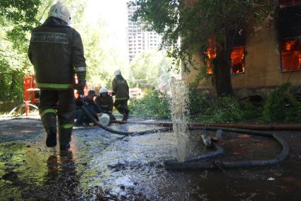 Вода брызжет из дыры в пожарном рукаве во время пожара в доме в Екатеринбурге