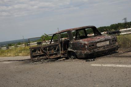 Станица Луганская. Авиация украинской армии подвергла станицу прямому авиаудару в 11 утра. Около 20 человек убиты и ранены. На снимке: сгоревшая `копейка`, в которой ехали супруги-пенсионеры.