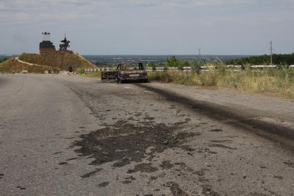 Станица Луганская. Авиация украинской армии подвергла станицу прямому авиаудару в 11 утра. Около 20 человек убиты и ранены. На снимке: сгоревшая `копейка`, в которой ехали супруги-пенсионеры.