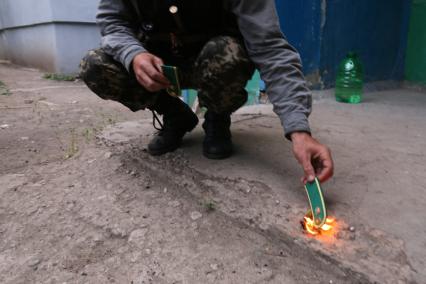 Луганск. Микрорайон Мирный. Областной пограничный отряд, территорию которую обстреливают ополченцы. На снимке: ополченец сжигает погоны пограничника.