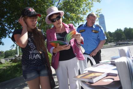 прохожие интересуются книгами в библиотеке под открытым небом  в Екатеринбурге