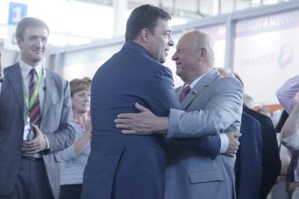 Губернатор Свердловской области Евгений Куйвашев (в центре) обнимает бывшего губернатора Эдуарда Росселя вправа) на открытии выставки Иннопром в Екатеринбурге