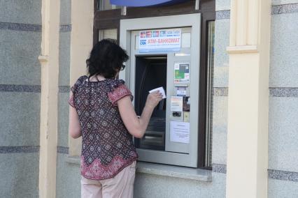 Луганск. На снимке: женщина снимает деньги в банкомате.