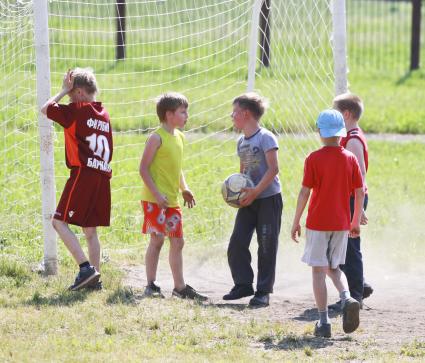 Дети играют в футбол в лагере.
