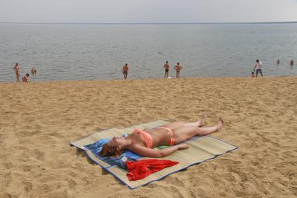 Девушка загорает на пляже озера Яровое Алтайского края.