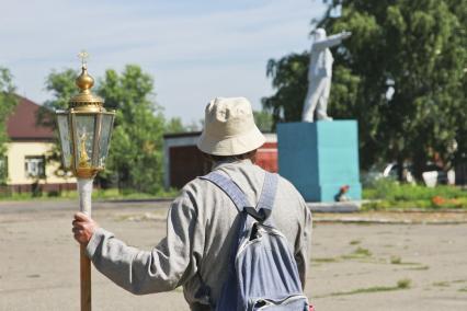 Крестный ход в село Коробейниково к иконе Казанской Божией Матери. Паломник с фонарем - подсвечником и памятник В.И. Ленину.