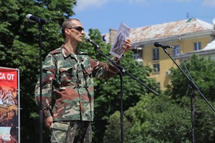 Луганск. День молодежи. На снимке: мужчина держит плакат `Вступайте в ряды народного ополчения`.