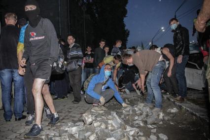 Киев. Активисты Украинской повстанческой армии (УПА) устроили погромы у посольства РФ. На снимке: активист кидает камень в здание посольства.