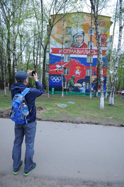 Нахимовский проспект 17к1. Графити на стене `Юра, мы исправились!` На снимке: молодой человек фотографирует на мобильный телефон.