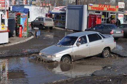 Бездорожье в Омске. Автомобиль проезжает по огромной луже.