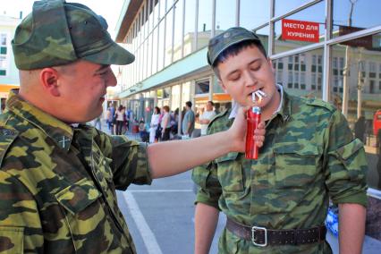 Солдат прикуривает три сигареты.