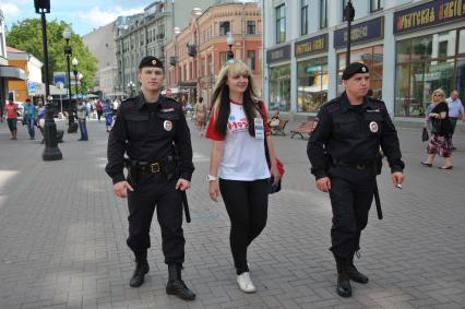 Волонтеры и полицейские патрулируют улицу Арбат для оказания помощи иностранцам.