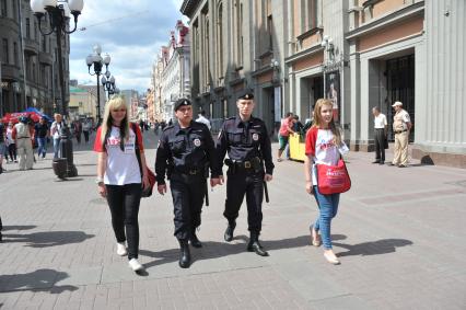 Волонтеры и полицейские патрулируют улицу Арбат для оказания помощи иностранцам.