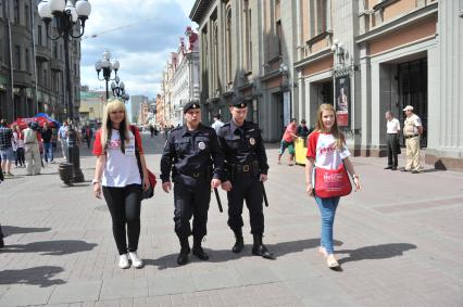 Волонтеры и полицейские патрулируют улицу Арбат для оказания помощи иностранцам.