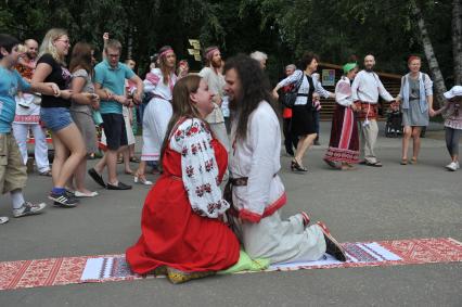 В парке `Кузьминки` отметили `День семьи, любви и верности`.  Реконструкция традиционного свадебного обряда, который существовал во времена Древней Руси. На снимке: мужчина и женщина  сидят на свадебном рушнике.