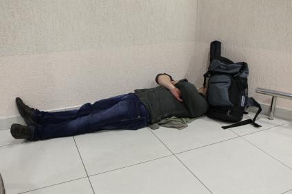 Транспортный коллапс в аэропорту  Шереметьево-2. На снимке: пассажир спит на полу.