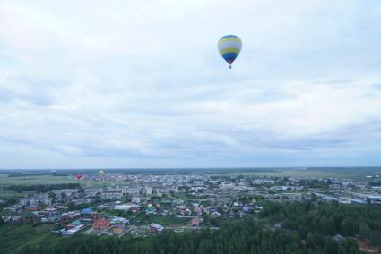 воздушный шар летит над землей во время фестиваля вздухоплавания\"небо на ладони\" в Каменске-Уральском\"