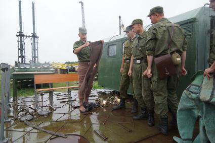 Солдат железнодорожных войск переодевается в утепленую одежду перед одеванием водолазного костюма