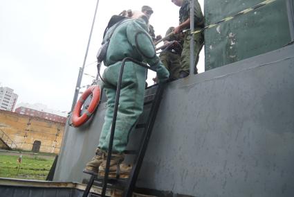 Солдат железнодорожных войск в водолазном костюме готовится к учебному погружению под воду