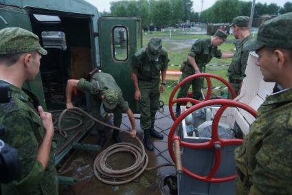 Солдаты-срочники железнодорожных войск разворачивают мобильную водолазную станцию